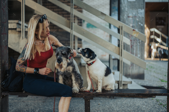 Middle Age Woman Petting Her Dogs While Out Walking Her Pet Stock Photo